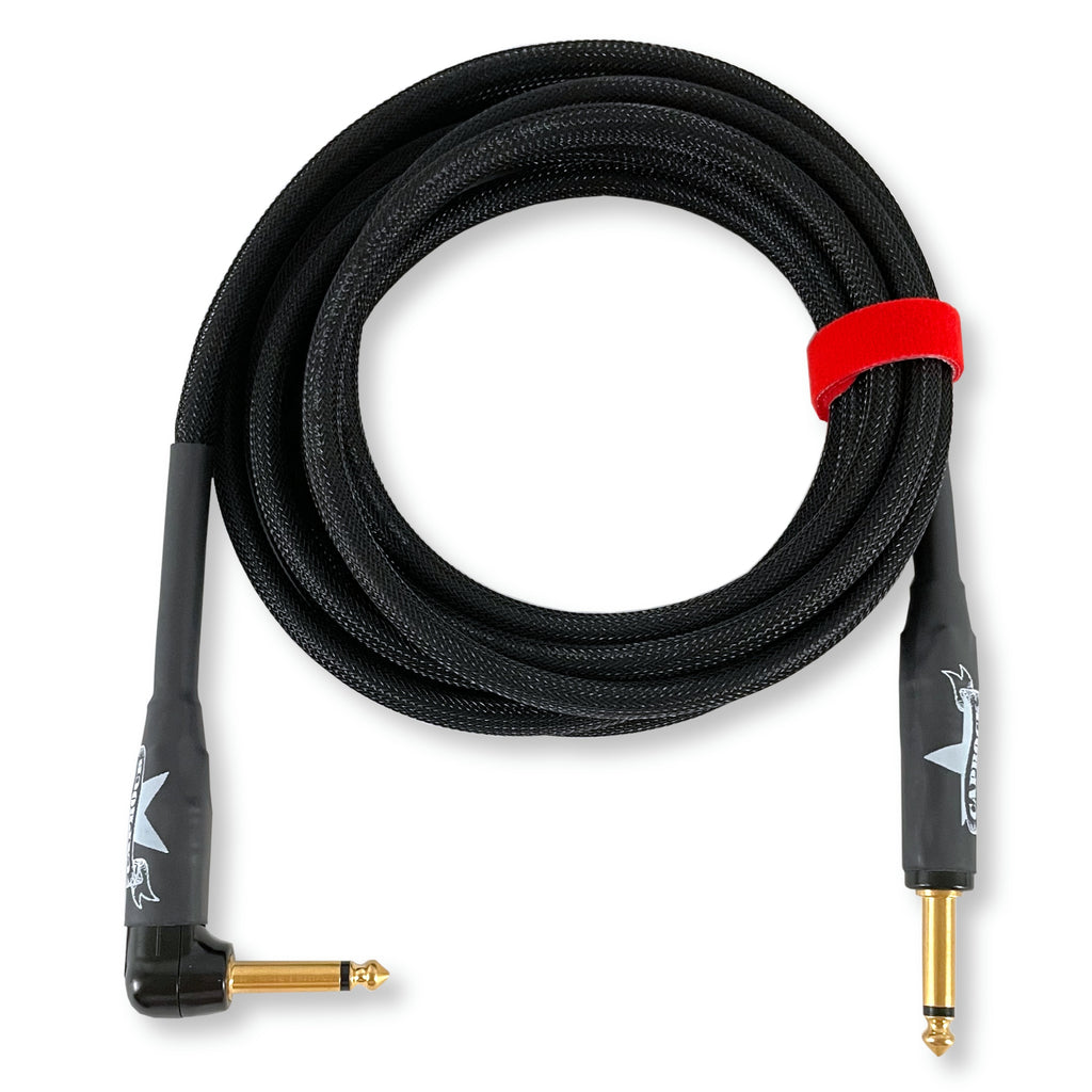 A coiled black audio cable with gold-plated jack connectors on both ends, secured with a red band, on a white background.