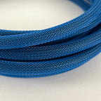 A close-up of a coiled blue braided cable or wire showing the detailed woven texture against a plain light background.